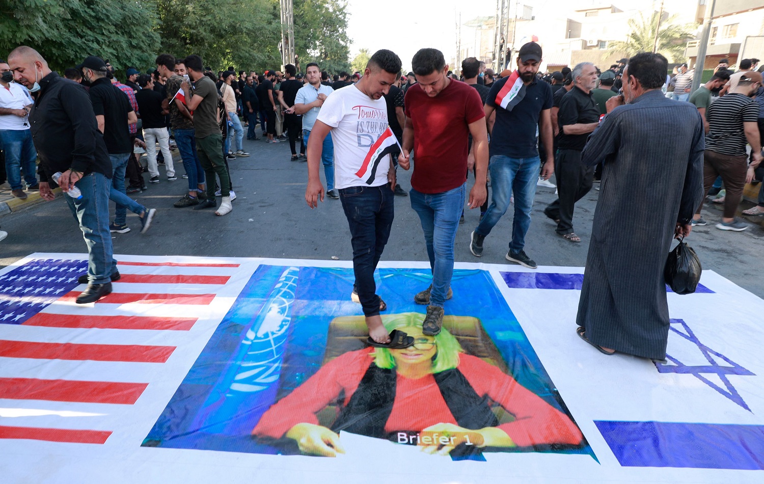 Supporters of the pro-Iran Hashd al-Shaabi militias step on a portrait of the head of the UN mission in Iraq Jeanine Hennis-Plasschaert (centre) in Baghdad on October 19, 2021. Photo: Ahmad al-Rubaye/AFP